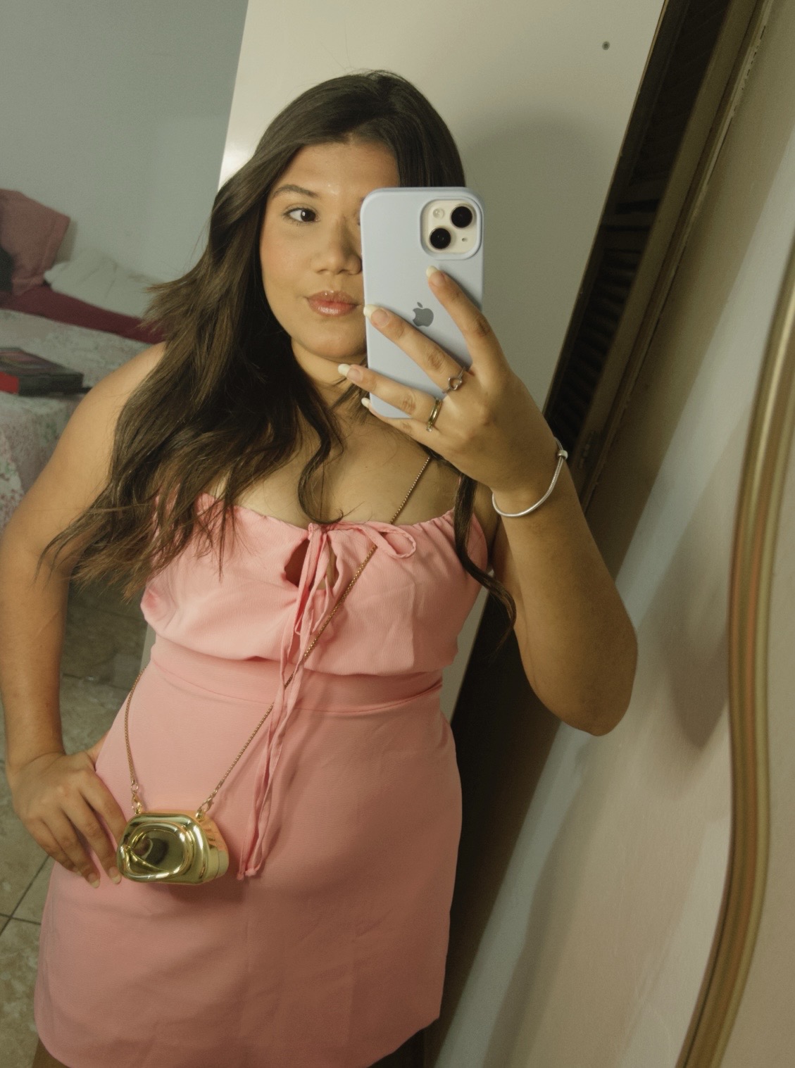 Modelo da Uso Bella com vestido rosa em selfie no espelho